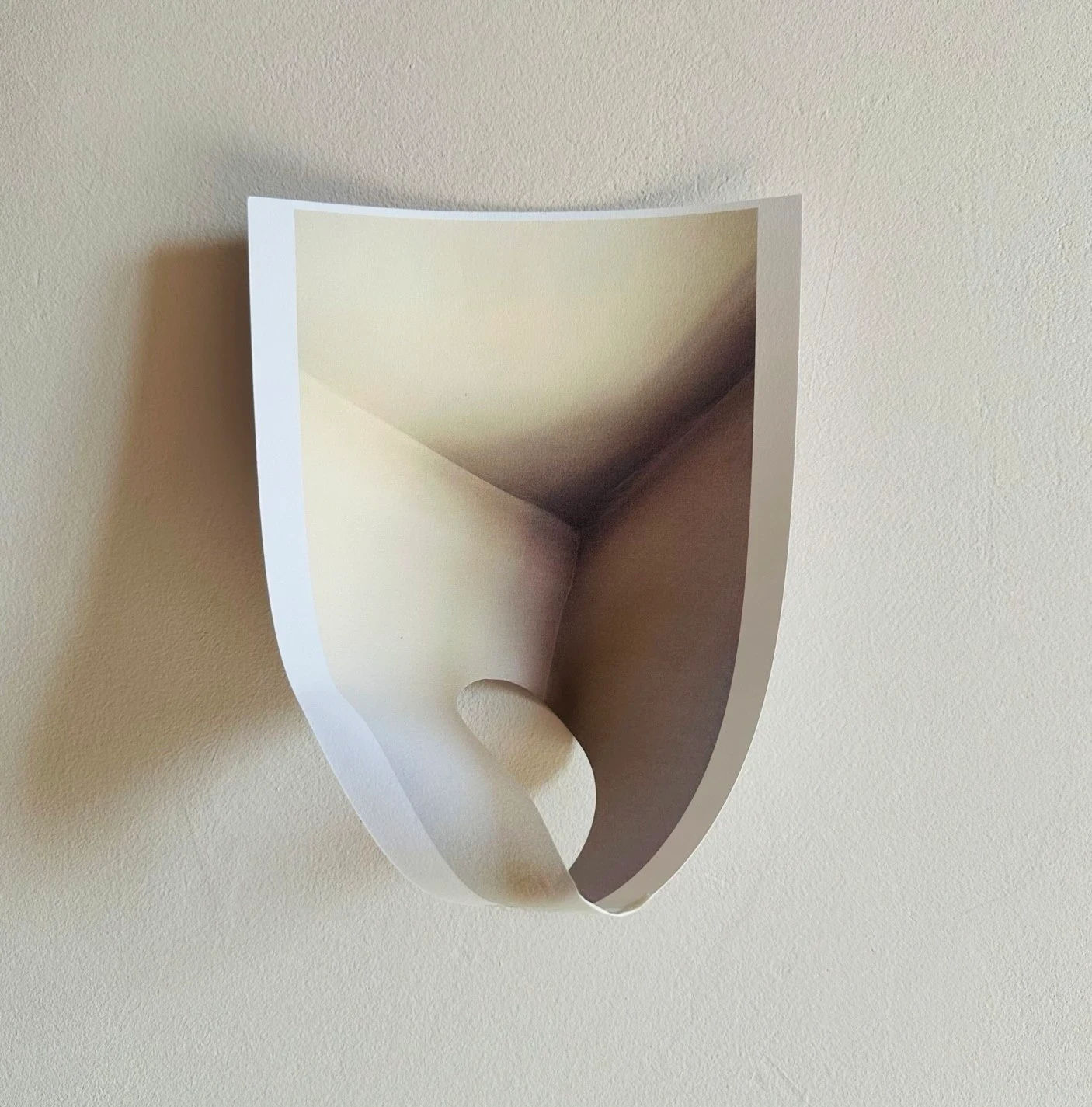 A folded photographic print with a rounded opening.