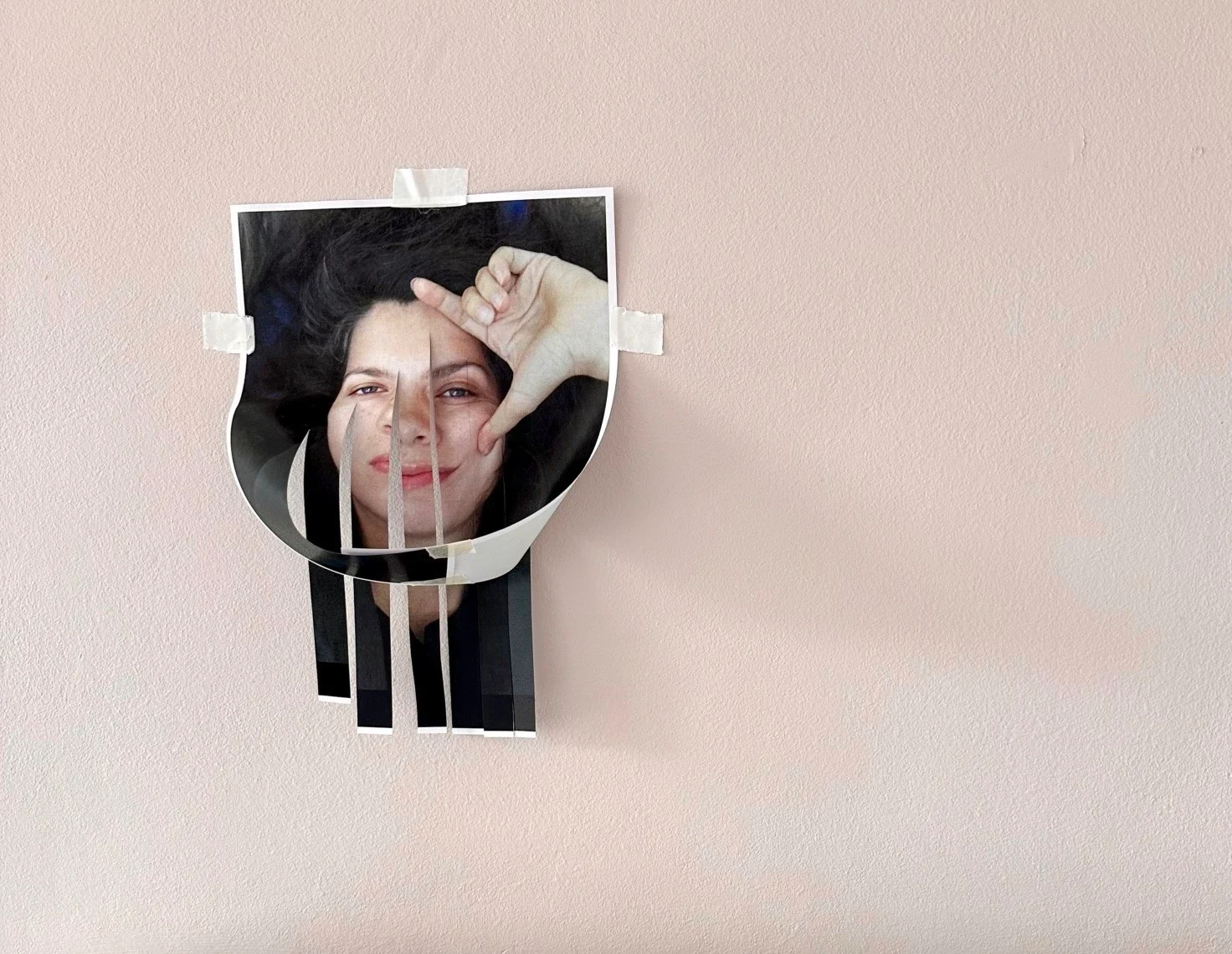 A printed portrait cut and folded into a small wall sculpture.