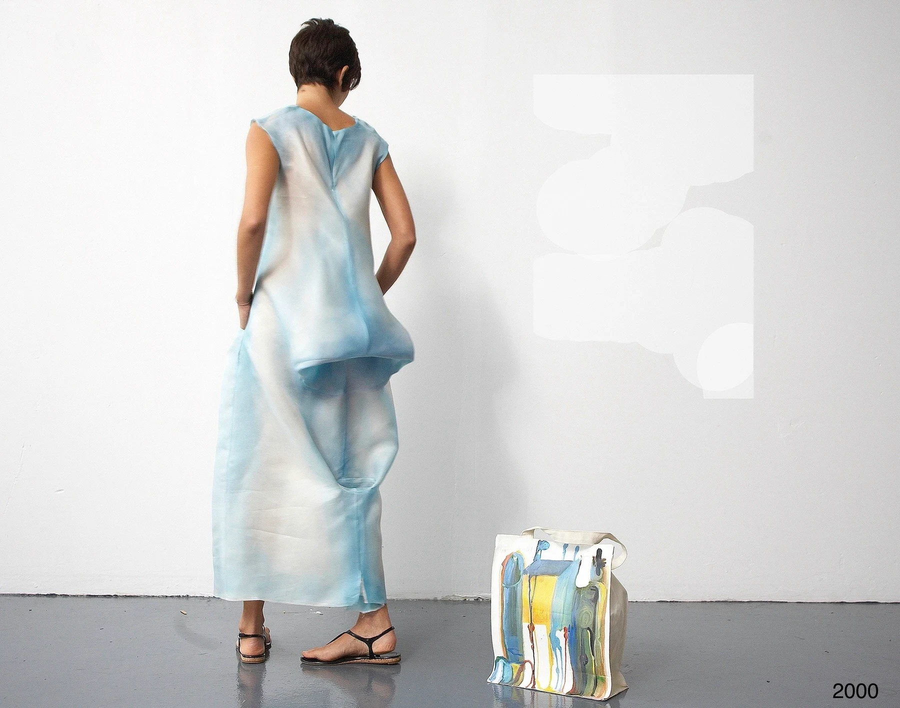 Rear view of a person wearing a loose pale blue garment.