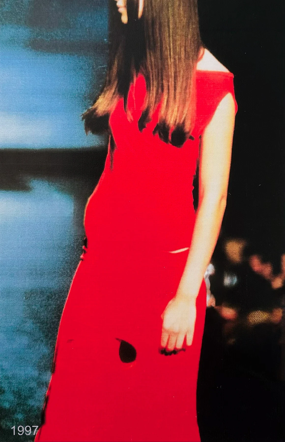 A person in a bright red dress with a circular opening.