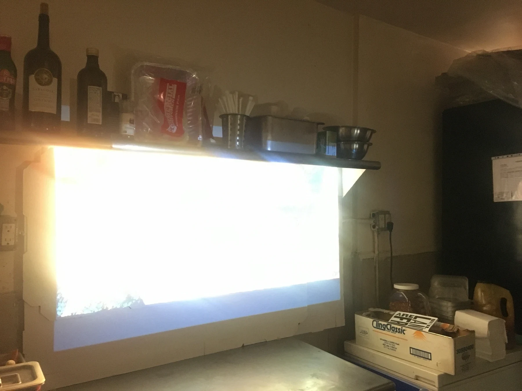 A bright projection on the pizza shop wall.