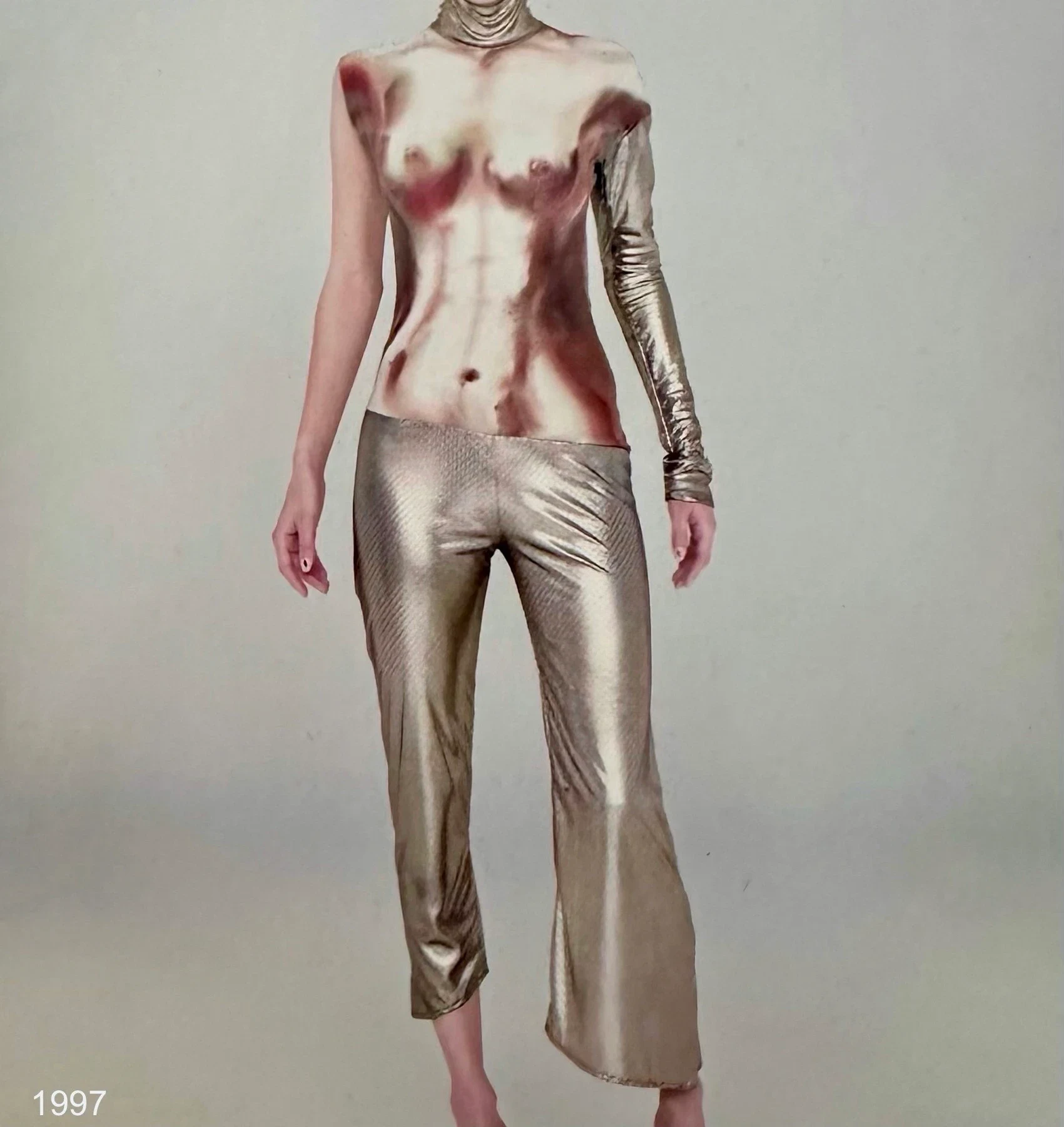 A person wearing a cream outfit with reddish printed shapes.